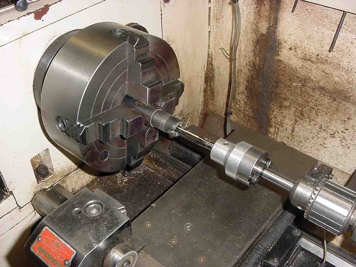 A Manson .32-20 reamer held in the chambering fixture is shown inserted into a lined barrel using the lathe tailstock.